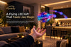 Flyokay MemoOrb LED flying ball floating with colorful light trails and personalized display text in a modern indoor setting